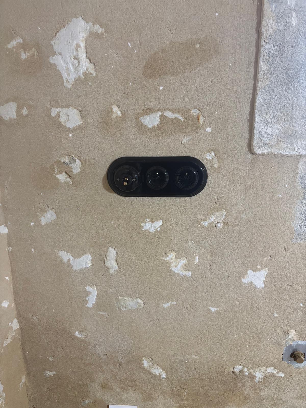 Appareillage noir sur murs en pierre : une installation électrique qui s’assume